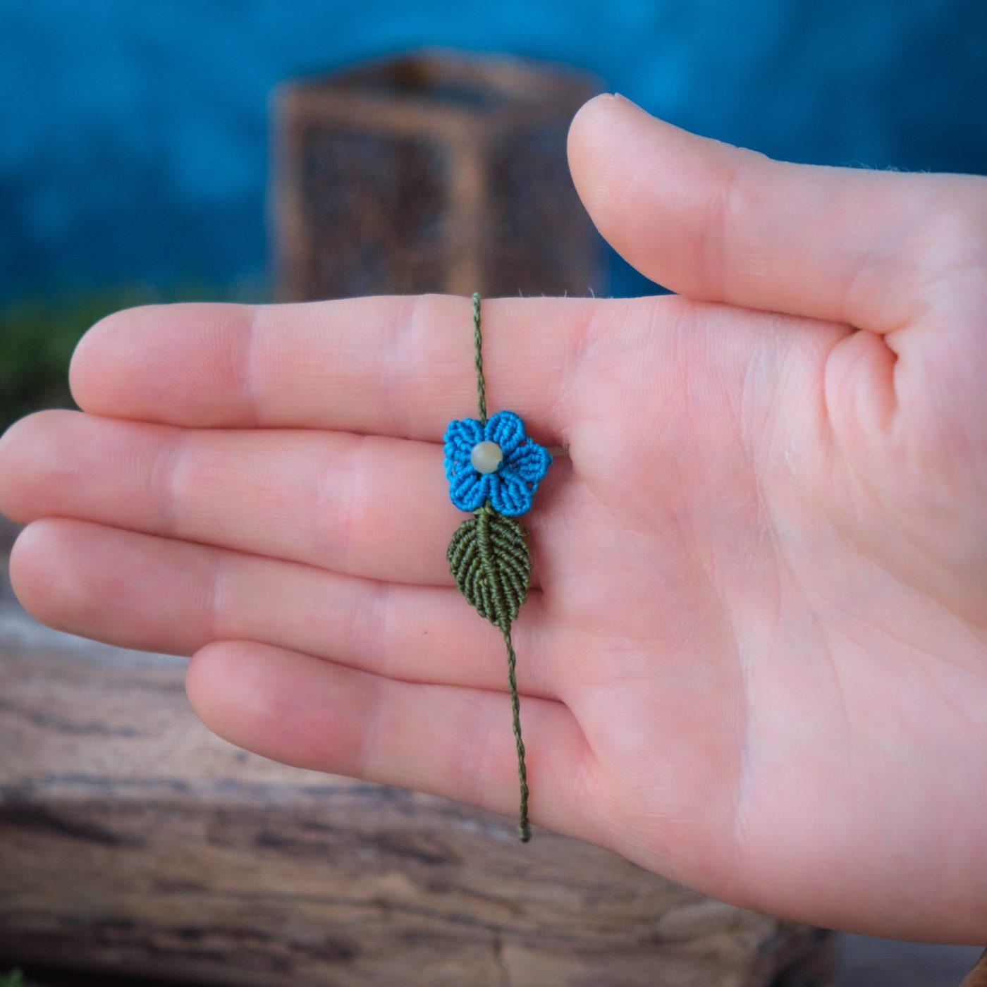 Blütentraum 'Alma' - Makramee Armband Schlicht mit grünem Blatt und blauer Blüte Blütentraum 'Alma' - Makramee Armband Schlicht mit grünem Blatt und blauer Blüte