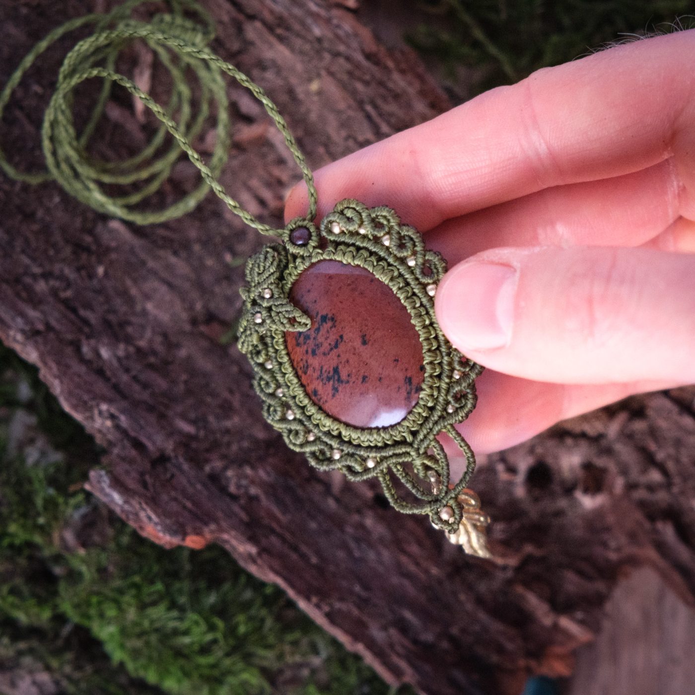 Elbenfporte 'Ellir' - Makramee Kettenanhänger mit Mahagoni Obsidian eingefasst mit Blattwerk und verspieltem Muster Elbenfporte 'Ellir' - Makramee Kettenanhänger mit Mahagoni Obsidian eingefasst mit Blattwerk und verspieltem Muster