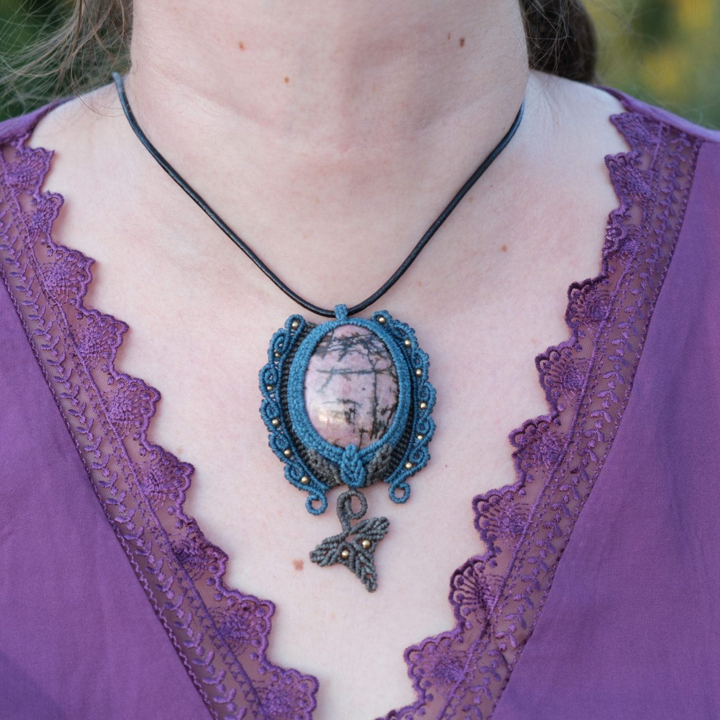 Waldpforte 'Lia' - Makramee Kettenanhänger mit Rhodonit eingefasst mit Blattwerk und verspieltem Muster Waldpforte 'Lia' - Makramee Kettenanhänger mit Rhodonit eingefasst mit Blattwerk und verspieltem Muster