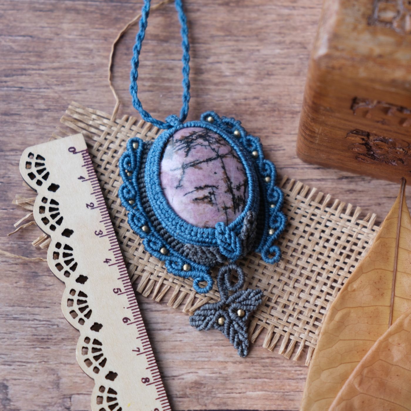 Waldpforte 'Lia' - Makramee Kettenanhänger mit Rhodonit eingefasst mit Blattwerk und verspieltem Muster Waldpforte 'Lia' - Makramee Kettenanhänger mit Rhodonit eingefasst mit Blattwerk und verspieltem Muster