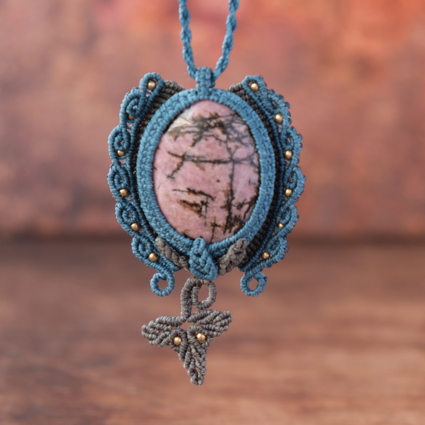 Waldpforte 'Lia' - Makramee Kettenanhänger mit Rhodonit eingefasst mit Blattwerk und verspieltem Muster Waldpforte 'Lia' - Makramee Kettenanhänger mit Rhodonit eingefasst mit Blattwerk und verspieltem Muster