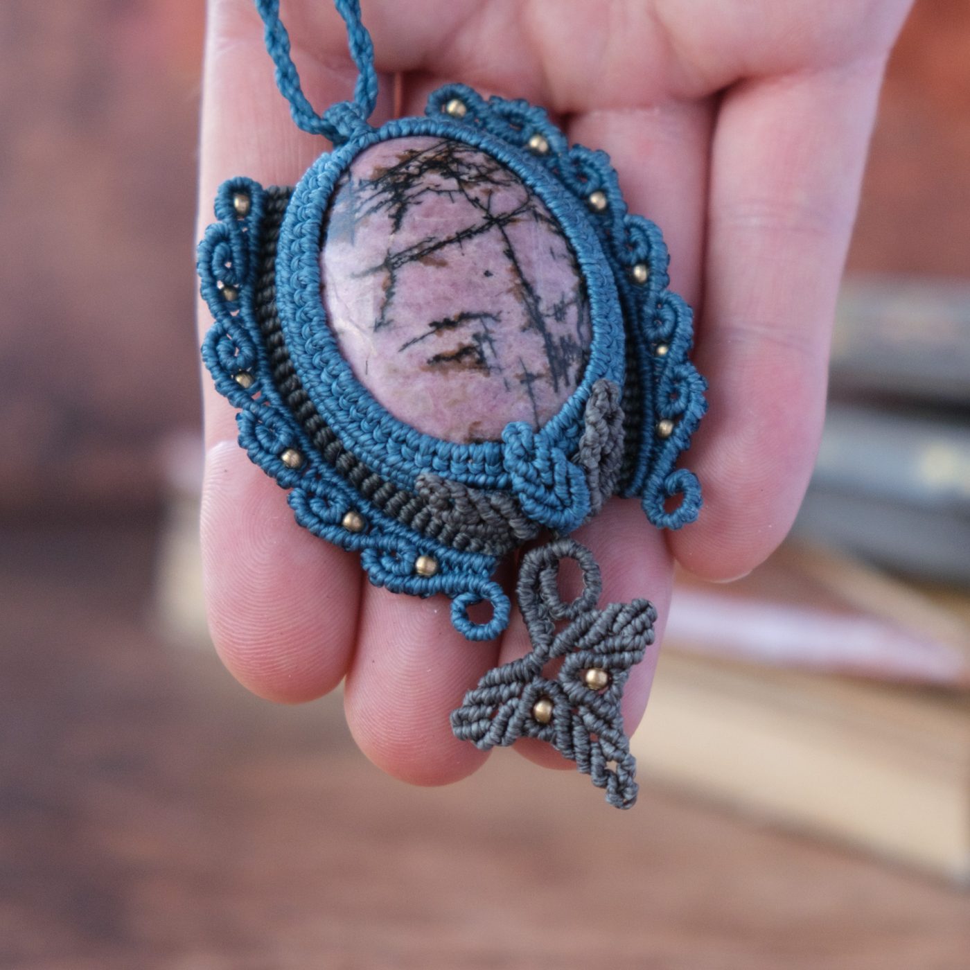 Waldpforte 'Lia' - Makramee Kettenanhänger mit Rhodonit eingefasst mit Blattwerk und verspieltem Muster Waldpforte 'Lia' - Makramee Kettenanhänger mit Rhodonit eingefasst mit Blattwerk und verspieltem Muster